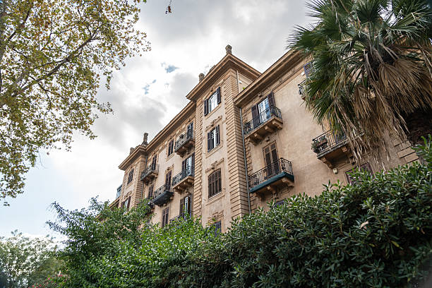 Historic building with green plants and blooming flowers on facade in Rome