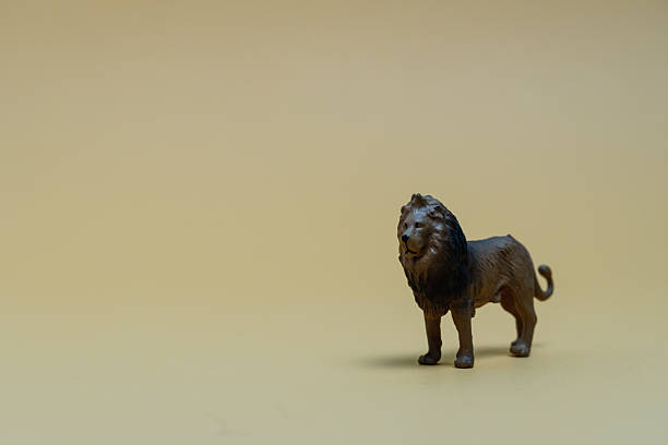 istock Plastic lion toy standing on a yellow background 2223334178