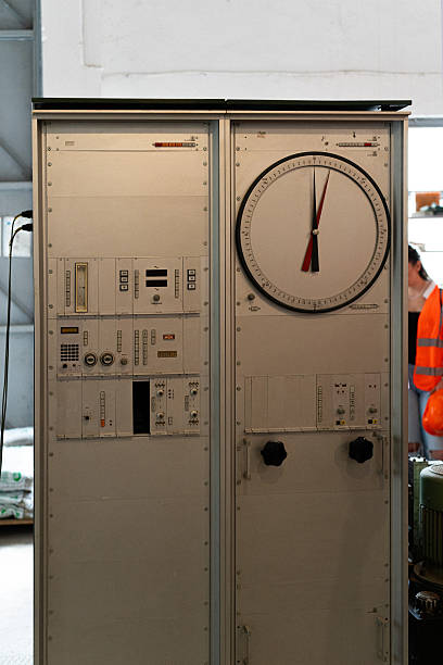 A weathered console featuring numerous gauges and dials stands within the industrial testing zone, likely used for precise monitoring of testing parameters and data collection.