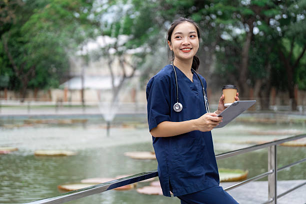 istock Doctor enjoying a break outdoors with clipboard and coffee 2223342098