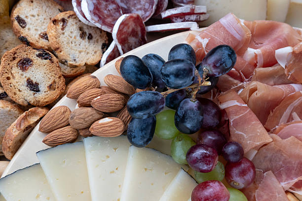 istock Appetizing cold spread with several cured meats and sliced cheeses, accompanied by tasty bread products 2223344459
