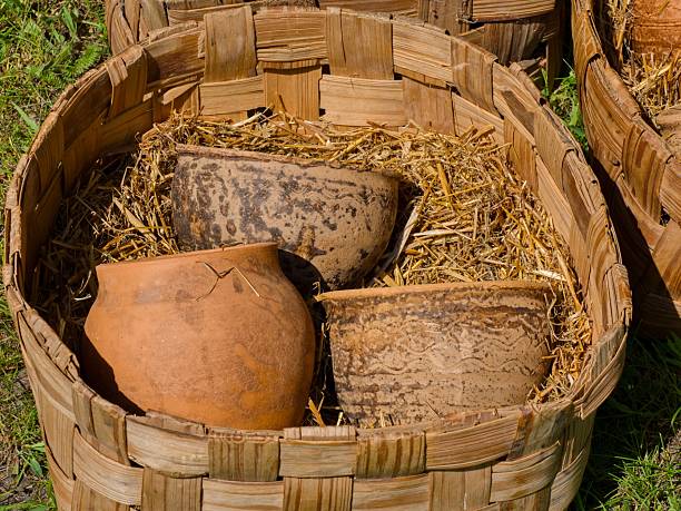 Ancient Style Clay Vessels in Wicker Basket. Old-fashioned Ceramic Containers in Outdoor Market Setting.