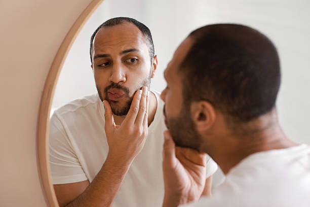 istock Worried man looking at mirror in bathroom 2223351241