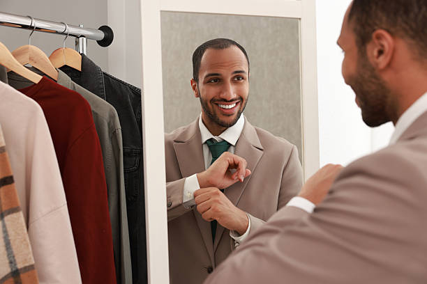 istock Smiling man dressing near mirror at home 2223351497