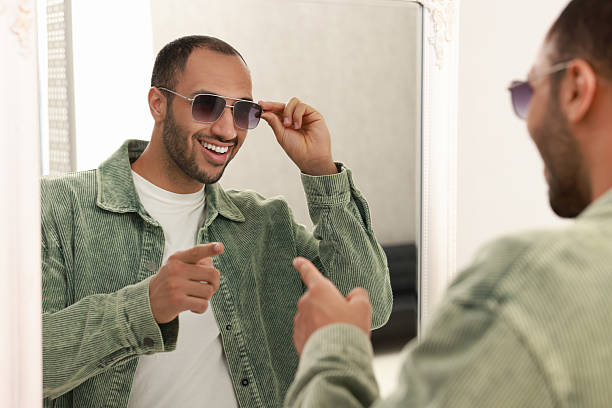 istock Smiling man looking at mirror at home 2223351500
