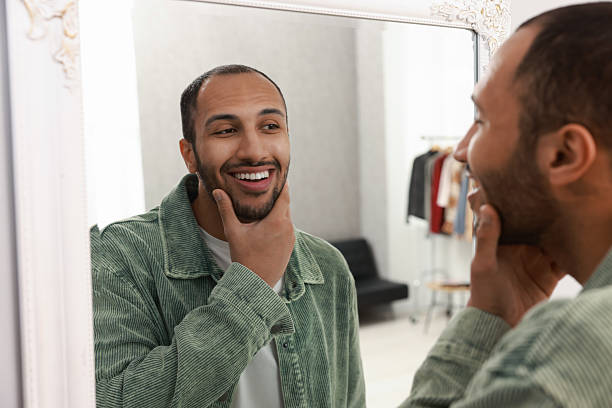 istock Smiling man looking at mirror at home 2223351534