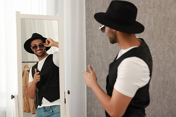 istock Smiling man looking at mirror at home 2223351543