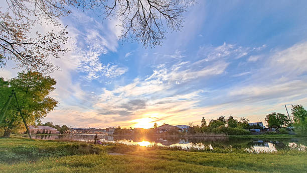 istock Scenic landscape featuring a tranquil lake reflecting a vibrant sunset, surrounded by lush greenery and trees, creating a serene atmosphere for relaxation and contemplation. Russia. Bryanskaya region. Nowozybkow 2223351738