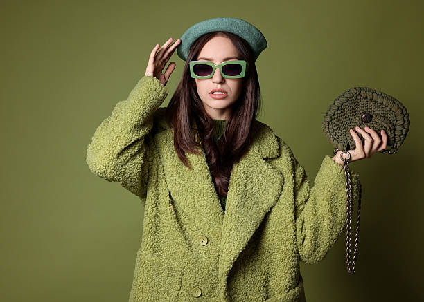 istock Young woman with stylish accessories on olive background 2223351773