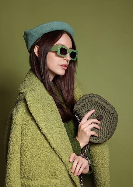 istock Young woman with stylish accessories on olive background 2223351834
