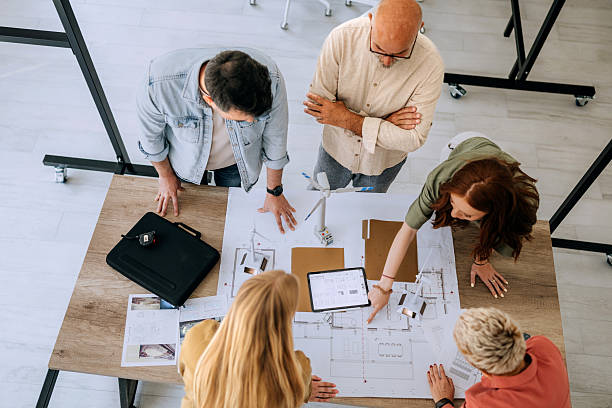 istock Group of colleagues working on wind turbine models at office 2223352547