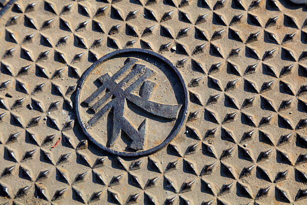 The three crosses design for the Dutch city of Amsterdam, derived from St Andrews Crosses, on a rusting metal manhole cover.