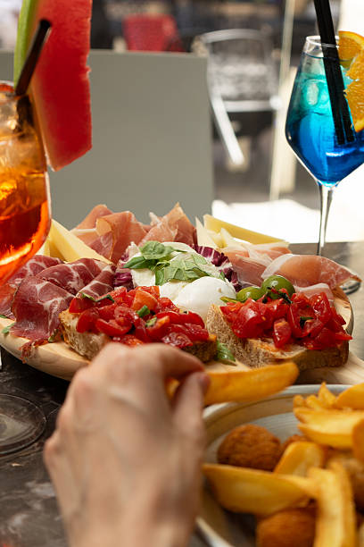 istock Cutting board with salami, mozzarella and bruschetta at a restaurant table 2223354236