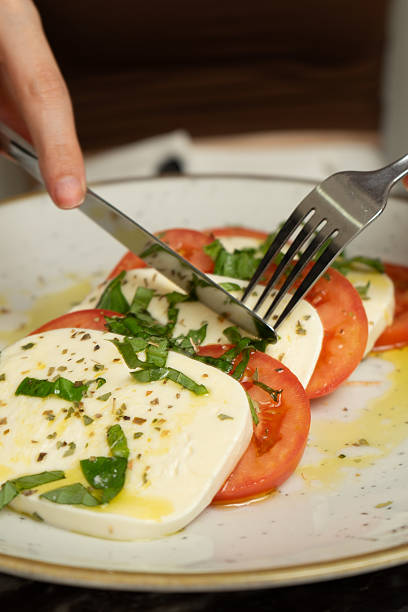 Tomato mozzarella with olive oil on a white plate