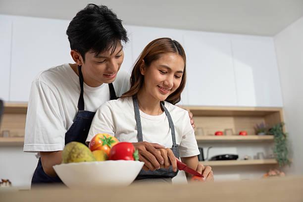 istock Couple Cooking Together. Smiling partners preparing a meal in a cozy kitchen. 2223354873