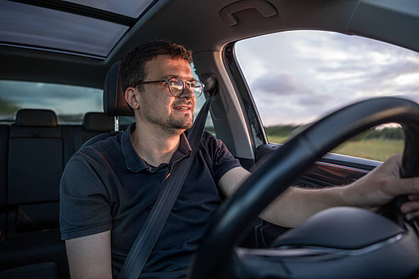 istock Smiling driver. Sunset light inside car. Calm road motion 2223355224
