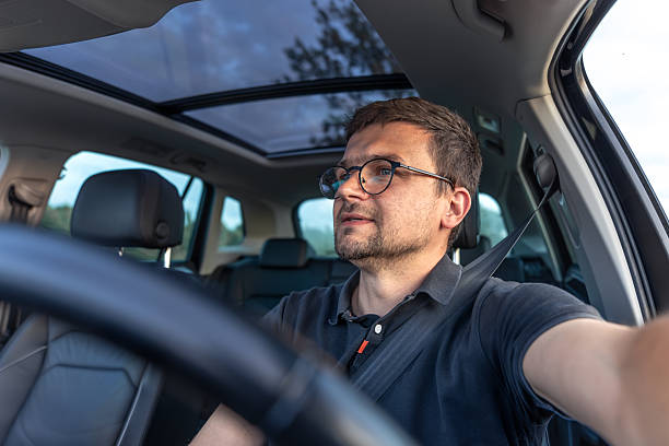 istock Man driving car. Focused driver in daylight. Calm modern interior. 2223355233