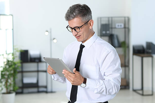 istock Businessman with glasses using tablet in office 2223355254