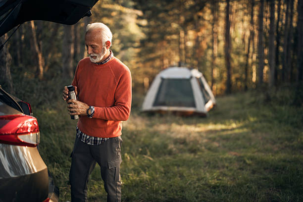 istock Man Outdoors near SUV and Tent in Forest Clearing 2223355405