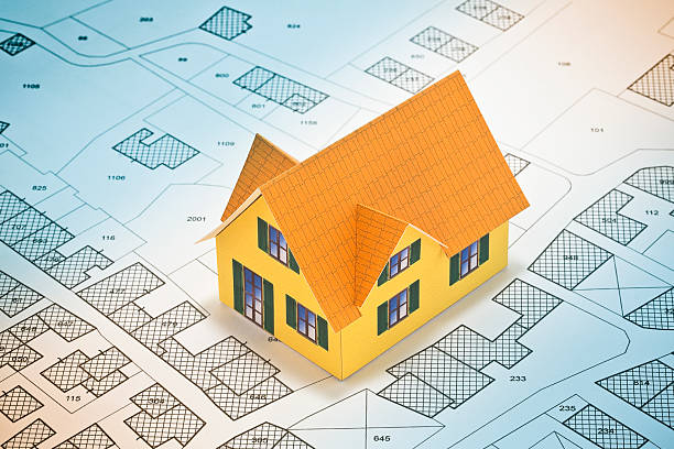 istock Cadastral map with buildings, building plot and free land parcel for house construction - building activity concept with cardboard house 2223356411