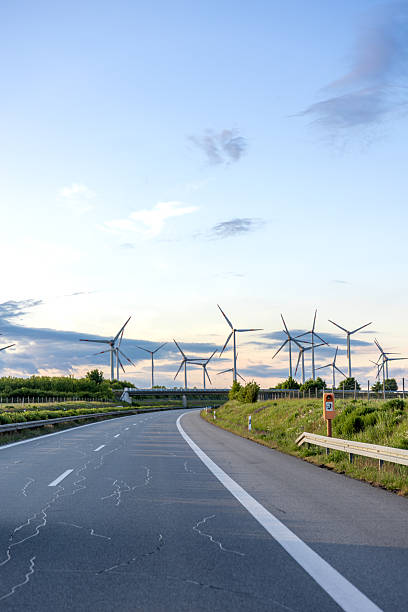 istock Path to the future. Wind turbines by road. Green energy concept. 2223357603