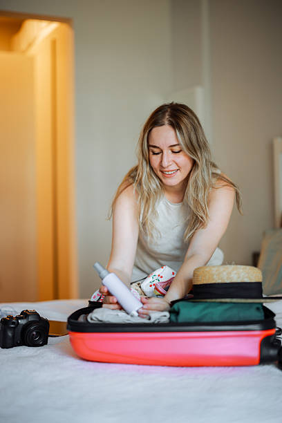 istock Happy woman preparing for travel with a suitcase 2223358004
