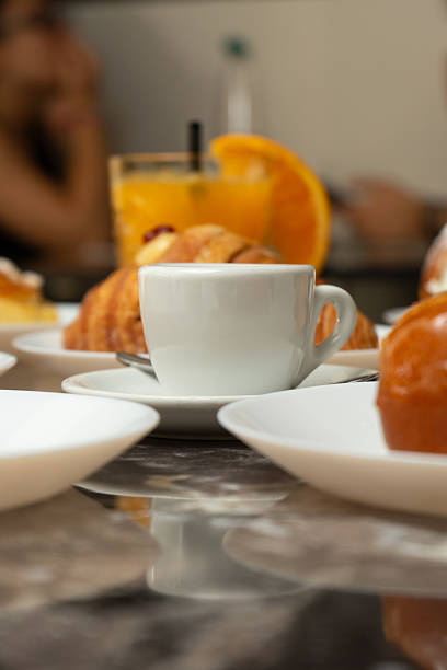 Breakfast with Brioches, coffee and orange juice at a bar table