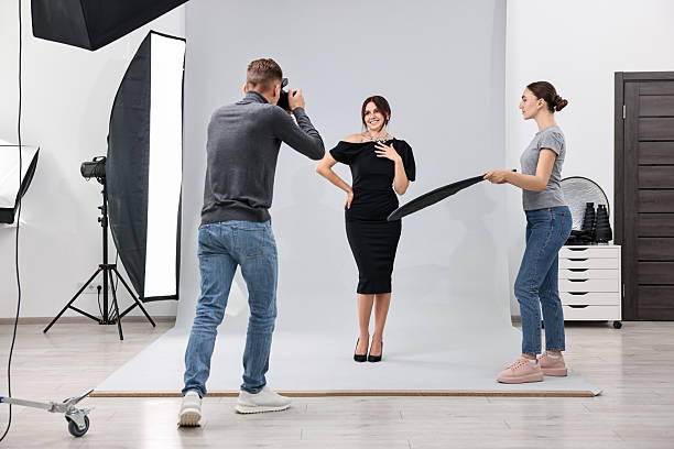 istock Photographer and assistant working with model in professional photo studio 2223361945