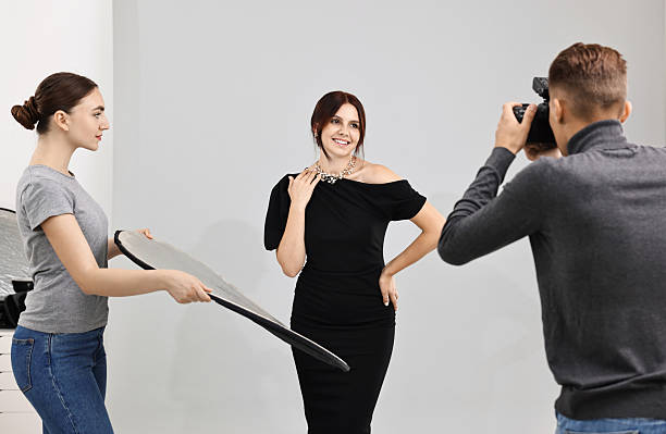 istock Photographer and assistant working with model in professional photo studio 2223361972