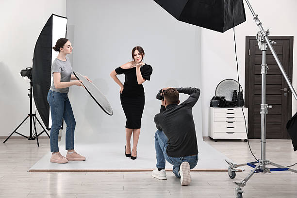 istock Photographer and assistant working with model in professional photo studio 2223361991