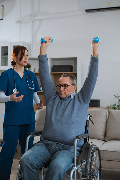 istock senior man doing exercise at clinic with physiotherapist. help of a therapist trainer during a rehabilitation session. 2223362573