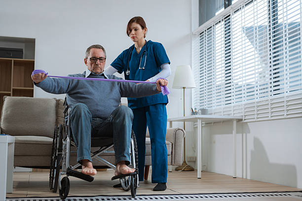 istock senior man doing exercise at clinic with physiotherapist. help of a therapist trainer during a rehabilitation session. 2223362598