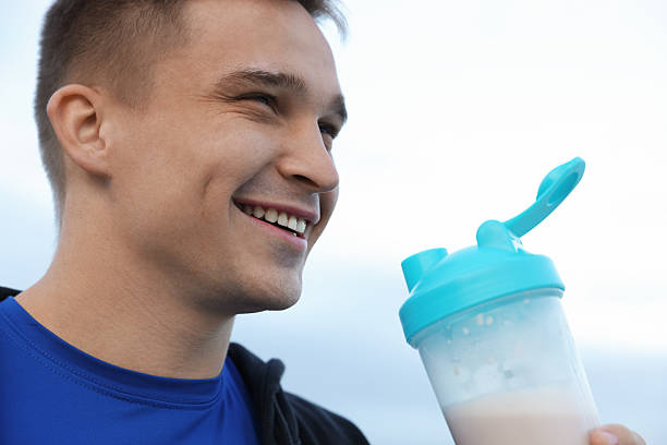 istock Smiling man with shaker of protein drink outdoors, closeup 2223363541
