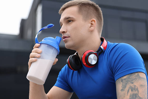 istock Handsome athletic man drinking protein shake outdoors 2223363862