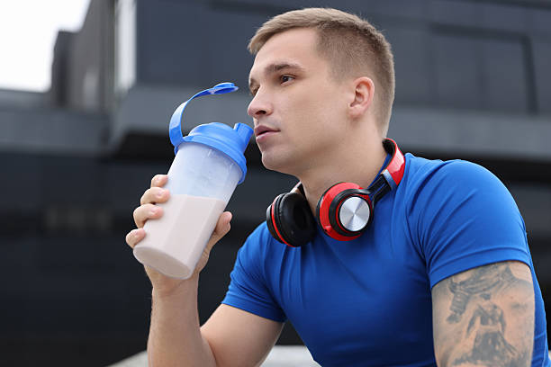 istock Handsome athletic man drinking protein shake outdoors 2223364118