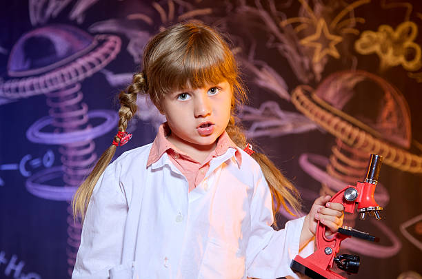 istock Funny girl holding microscope in hand looking at camera 2223365205