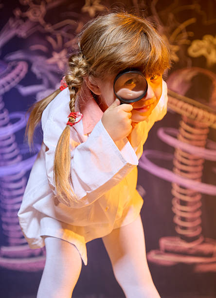 istock Funny girl leaning forward looking through magnifying glass 2223365208
