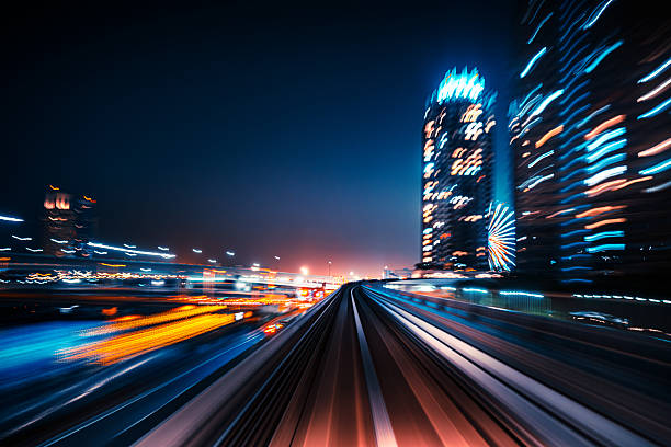 Experience the dynamic motion blur of a fast train moving through Tokyo's vibrant nightscape, showcasing modern architecture and vivid colors in an urban setting.