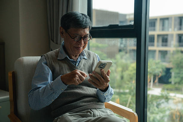 istock Cheerful senior man connecting with loved ones through a FaceTime call on his smartphone from a wellness-focused senior living community 2223367680