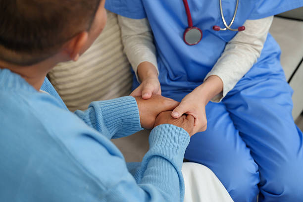Physiotherapist attentively listens while holding elderly patient's hands, offering comfort and understanding to promote healing and emotional resilience during recovery.