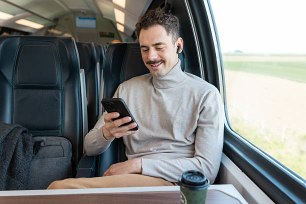 istock Man enjoying a peaceful train ride while browsing his phone 2223379350