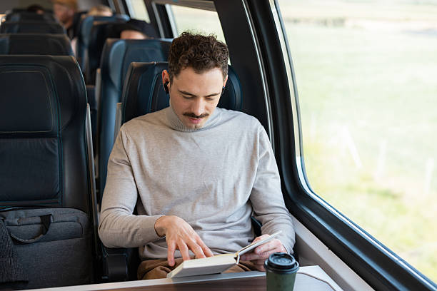 istock Man reading a book and enjoying coffee during a train journey 2223379387