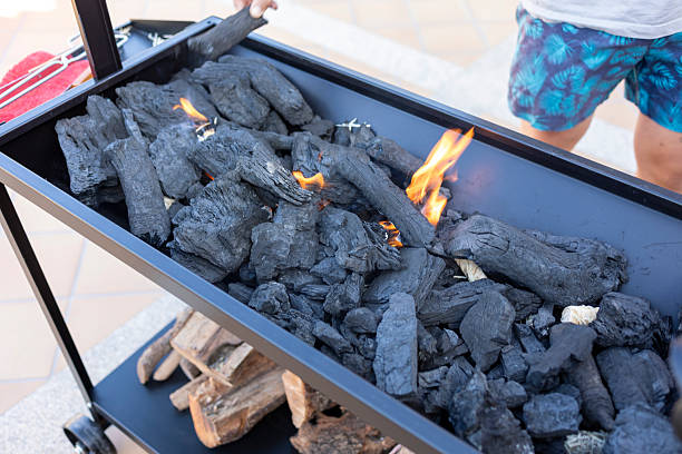 Charcoal pieces catching fire in a barbecue grill, ready for outdoor cooking and grilling