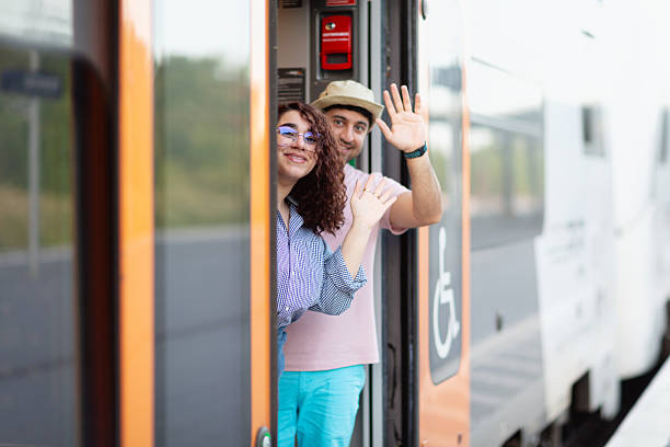 istock tourist couple waving goodbye from train door 2223387728