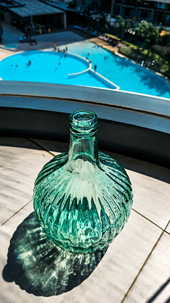 istock Sunlit Glass Bottle with Pool and Modern Architecture 2223390894