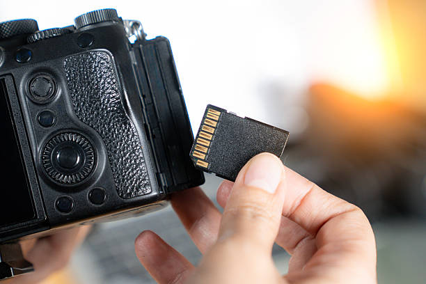 istock Photographer's hand removing memory card from digital camera  data and workflow concept 2223399999