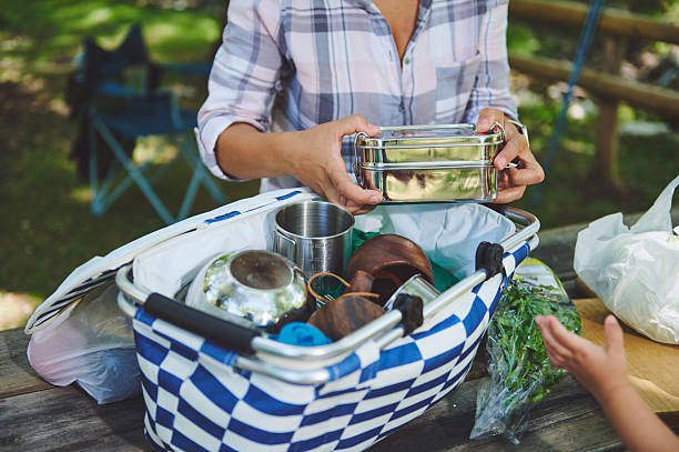 Woman Packing a Picnic Basket Outdoors in a Natural Setting