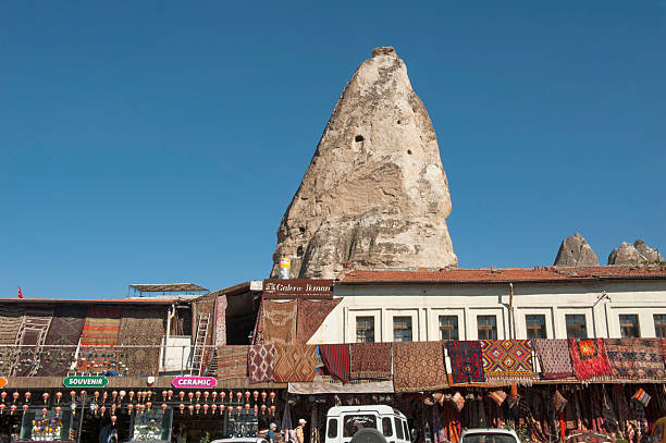 Cappadocia, Turkey. September 19th 2018A huge rock formation and shops selling traditional rugs and carpets in Goreme, Cappadocia, Anatolia, Turkey