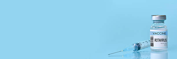 istock Rotavirus vaccine bottle and syringe placed on a clean blue background, representing healthcare, medical science, immunization awareness, and disease prevention. Banner with copy space 2223402546