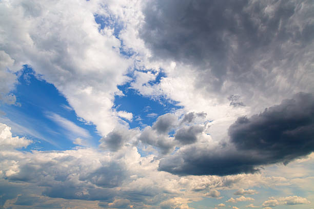 istock White clouds, blue sky, and gray rain clouds in one skyline, different types of clouds in one frame illuminated by sunlight in the blue sky 2223403810